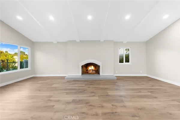 a view of empty room with window and wooden floor