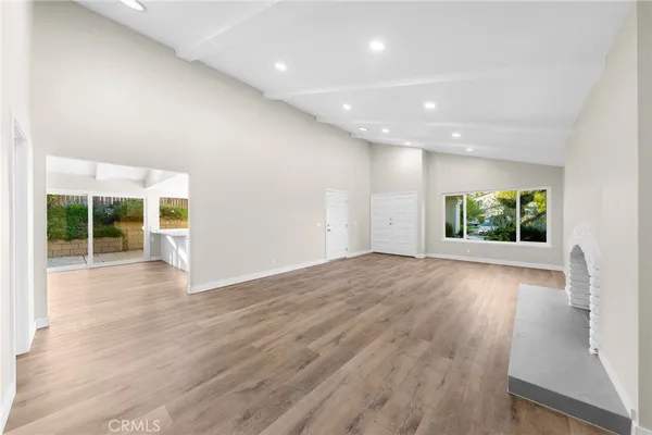 an empty room with window and fire place