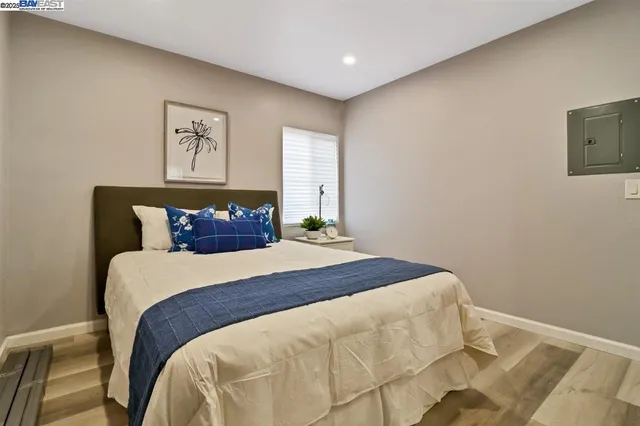 a bedroom with a bed and painting on the wall