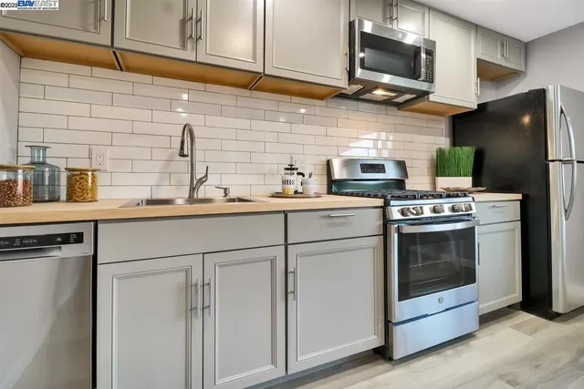 a kitchen with stainless steel appliances a stove microwave and refrigerator