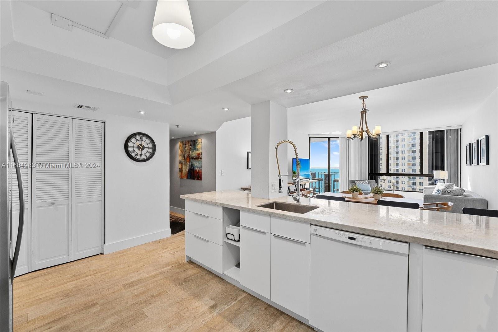 520 Brickell Key Drive, Unit A1513 Miami, FL 33131 - Photo 11 of 22 a large white kitchen with a sink and a refrigerator