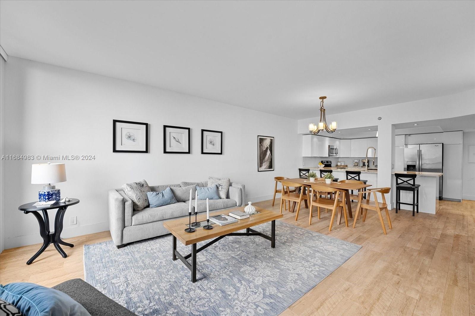 520 Brickell Key Drive, Unit A1513 Miami, FL 33131 - Photo 6 of 22 a living room with furniture and a dining table with wooden floor
