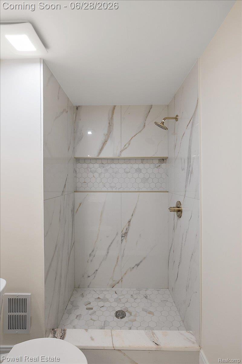1447 Ravineview Court, Unit C12 Bloomfield Hills, MI 48304 - Photo 36 of 49 Shower stall featuring white marble-look wall tiles with veining, a hexagonal mosaic tile floor, and a built-in shower niche