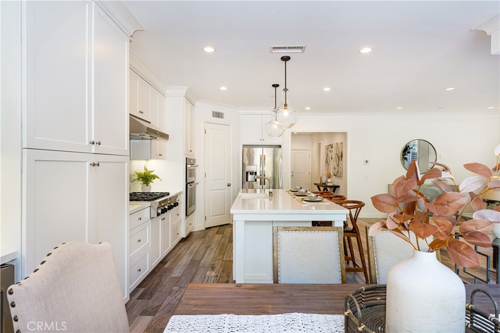 57 Bandana Irvine, CA 92602 - Photo 9 of 32 a view of a kitchen with kitchen island stainless steel appliances wooden floor dining table and chairs