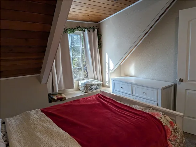 a bed sitting in a bedroom next to a window