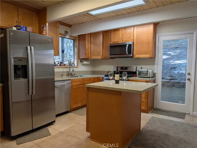 a kitchen with stainless steel appliances granite countertop a refrigerator stove a sink and a microwave