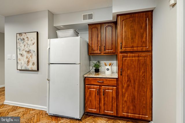 a kitchen with stainless steel appliances granite countertop sink refrigerator dining table and chairs