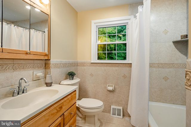 a view of empty room with window and painting on the wall