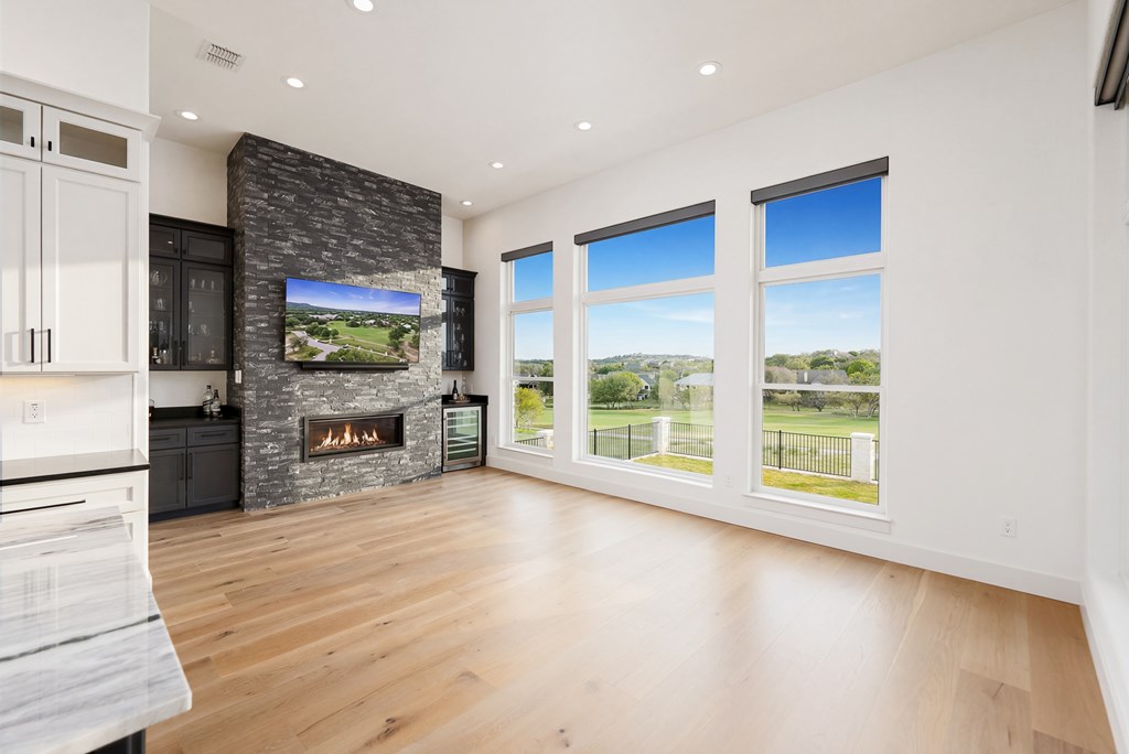 1029 Club House Road Kerrville, TX 78028 - Photo 18 of 62 a view of an empty room with a fireplace and a large window