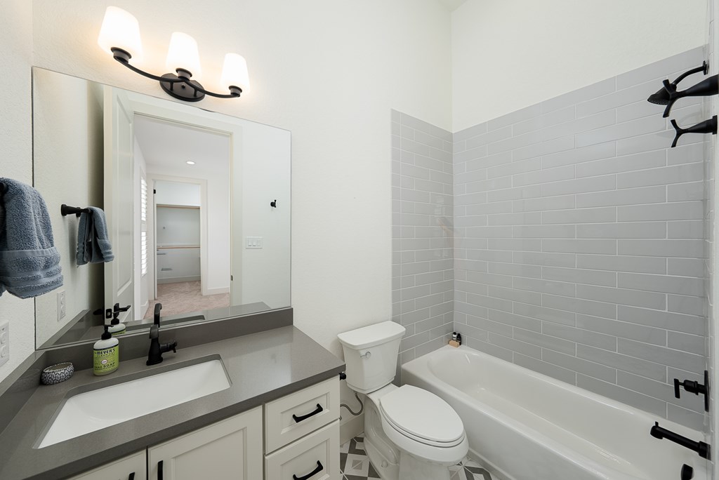 1029 Club House Road Kerrville, TX 78028 - Photo 31 of 62 a bathroom with a sink a toilet and a mirror