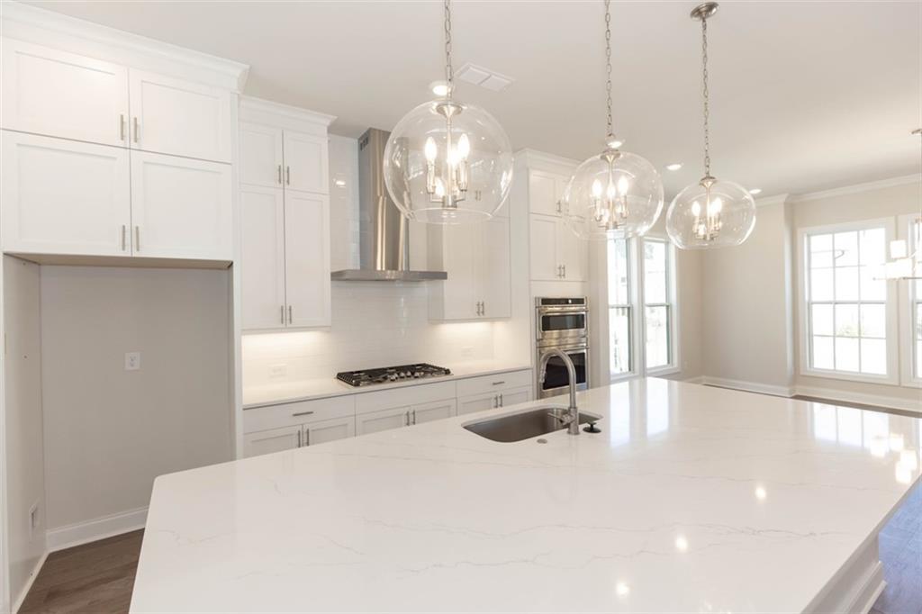 161 Basil Street Cumming, GA 30040 - Photo 1 of 1 a view of a kitchen with granite countertop a sink stainless steel appliances and cabinets