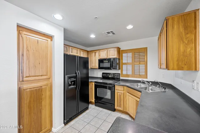 a kitchen with stainless steel appliances granite countertop a refrigerator and a stove top oven