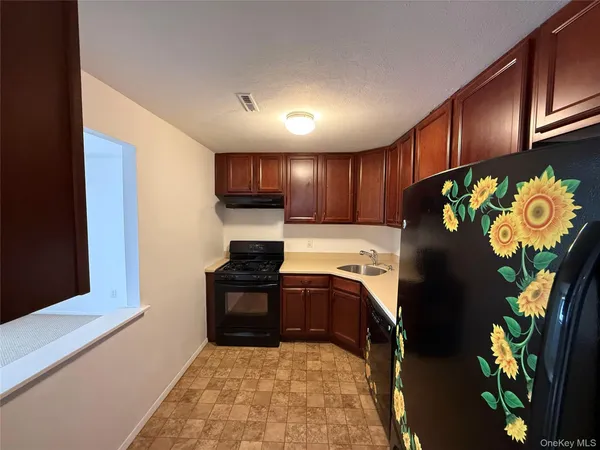 a kitchen with stainless steel appliances granite countertop a refrigerator a stove top oven a sink and dishwasher