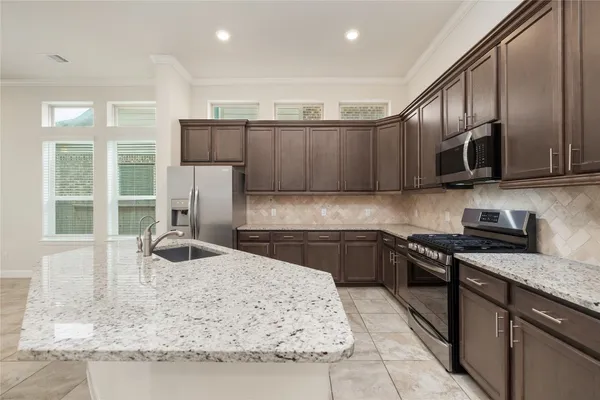 a kitchen with stainless steel appliances granite countertop a sink and a stove