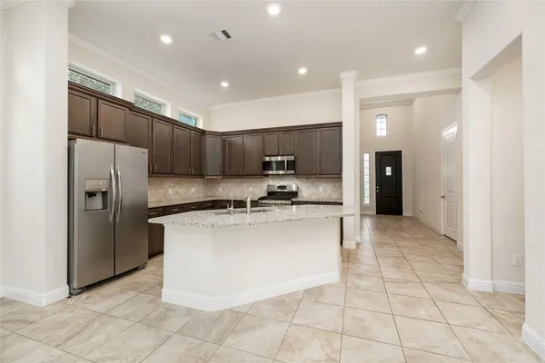 a kitchen with stainless steel appliances a refrigerator sink and cabinets