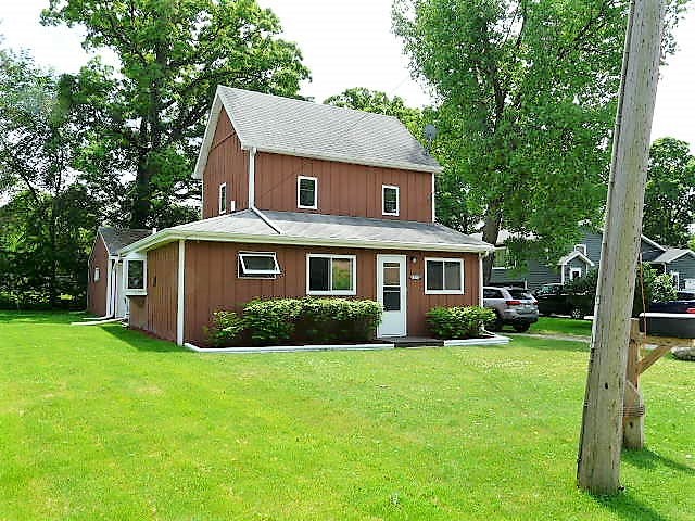 a front view of a house with yard and green space