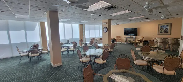 a living room with patio furniture and potted plants