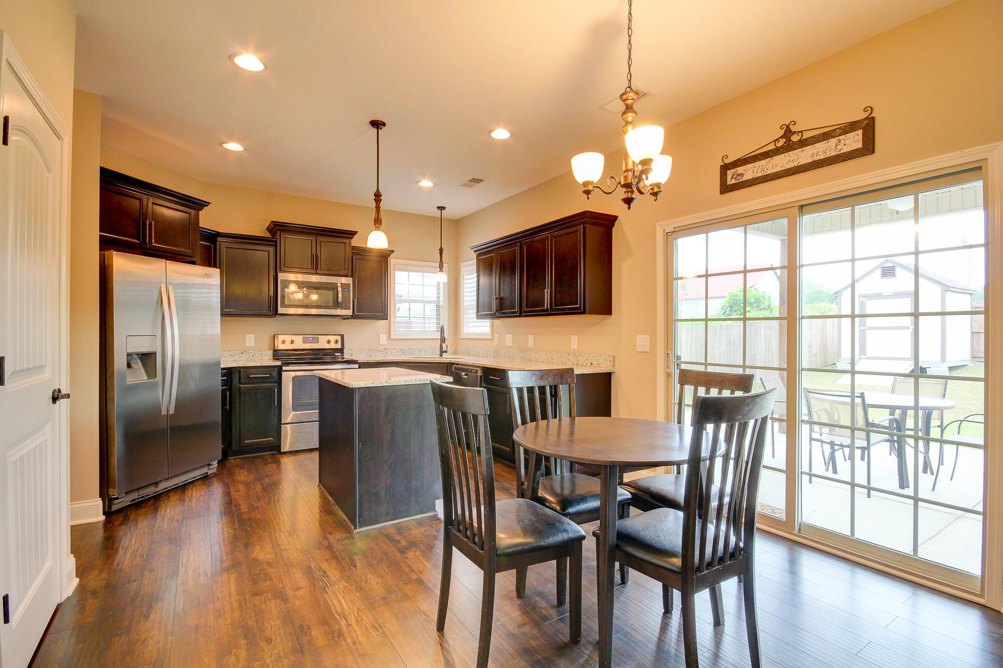 1012 Barnhill Road Clarksville, TN 37043 - Photo 4 of 18 a kitchen with granite countertop a table chairs refrigerator and microwave