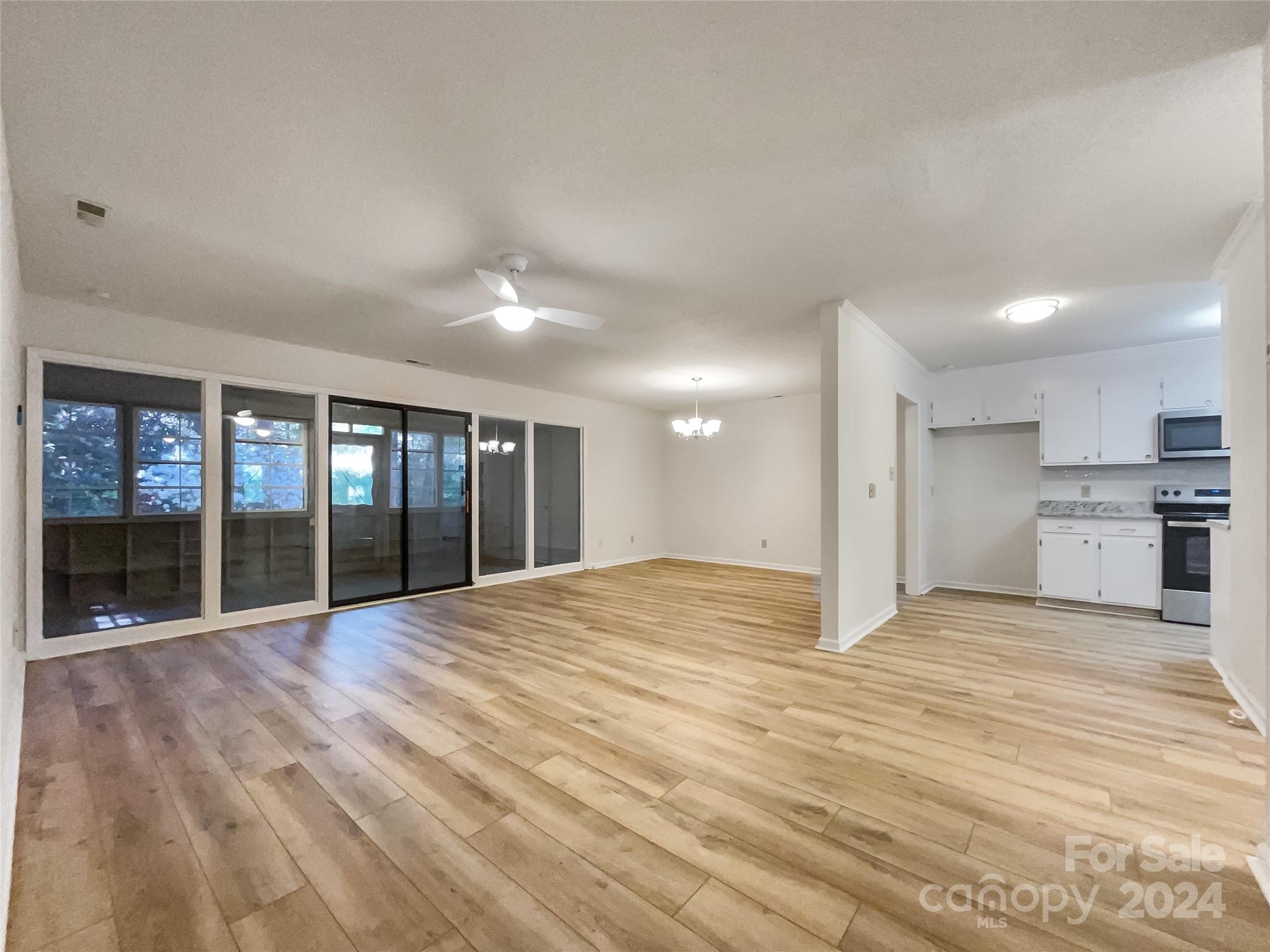 123 David Court Fort Mill, SC 29715 - Photo 13 of 18 a view of an empty room with wooden floor and a kitchen