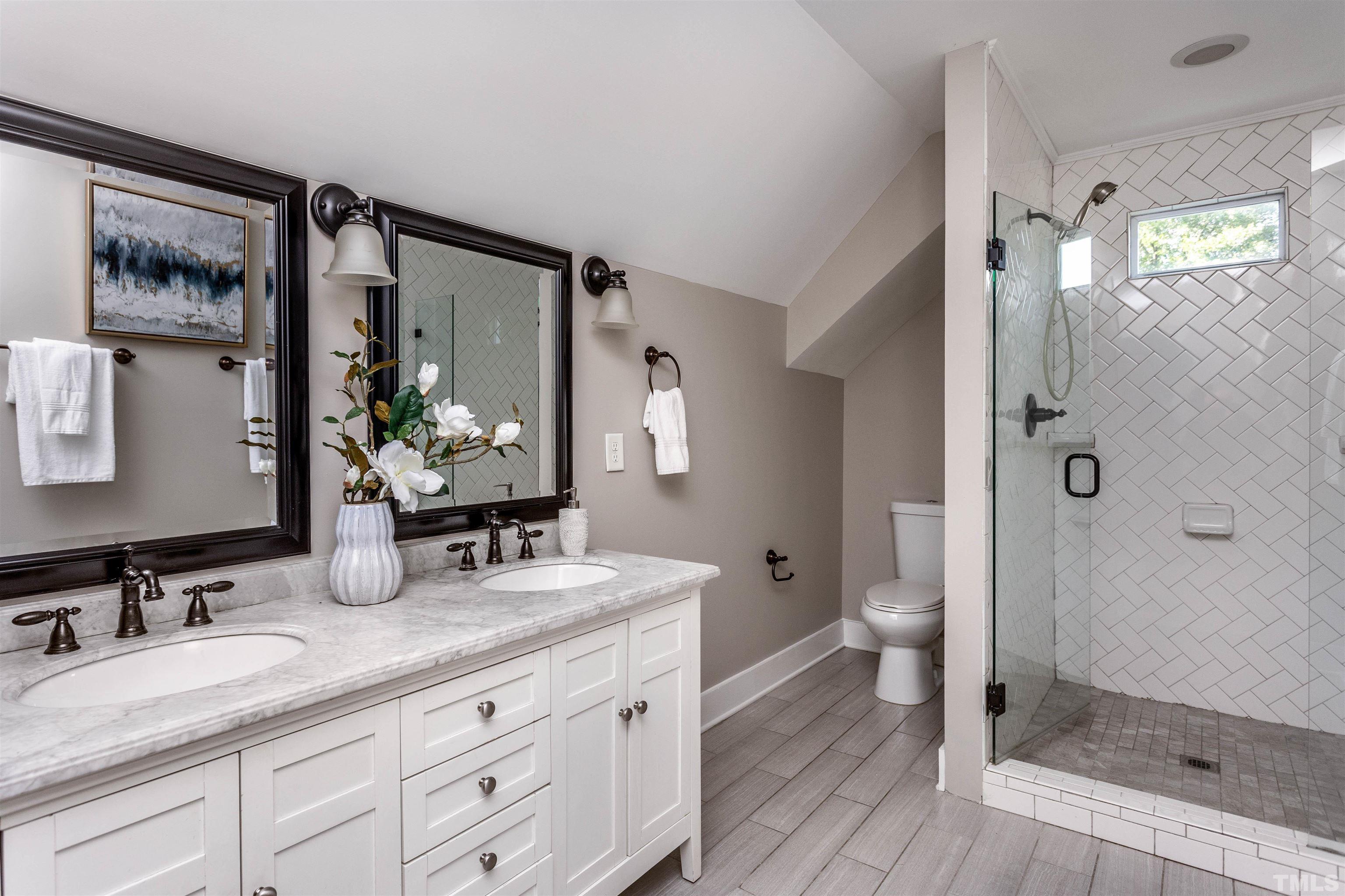 312 Freeman Street Raleigh, NC 27601 - Photo 18 of 30 a bathroom with a granite countertop sink toilet a mirror a vanity and shower