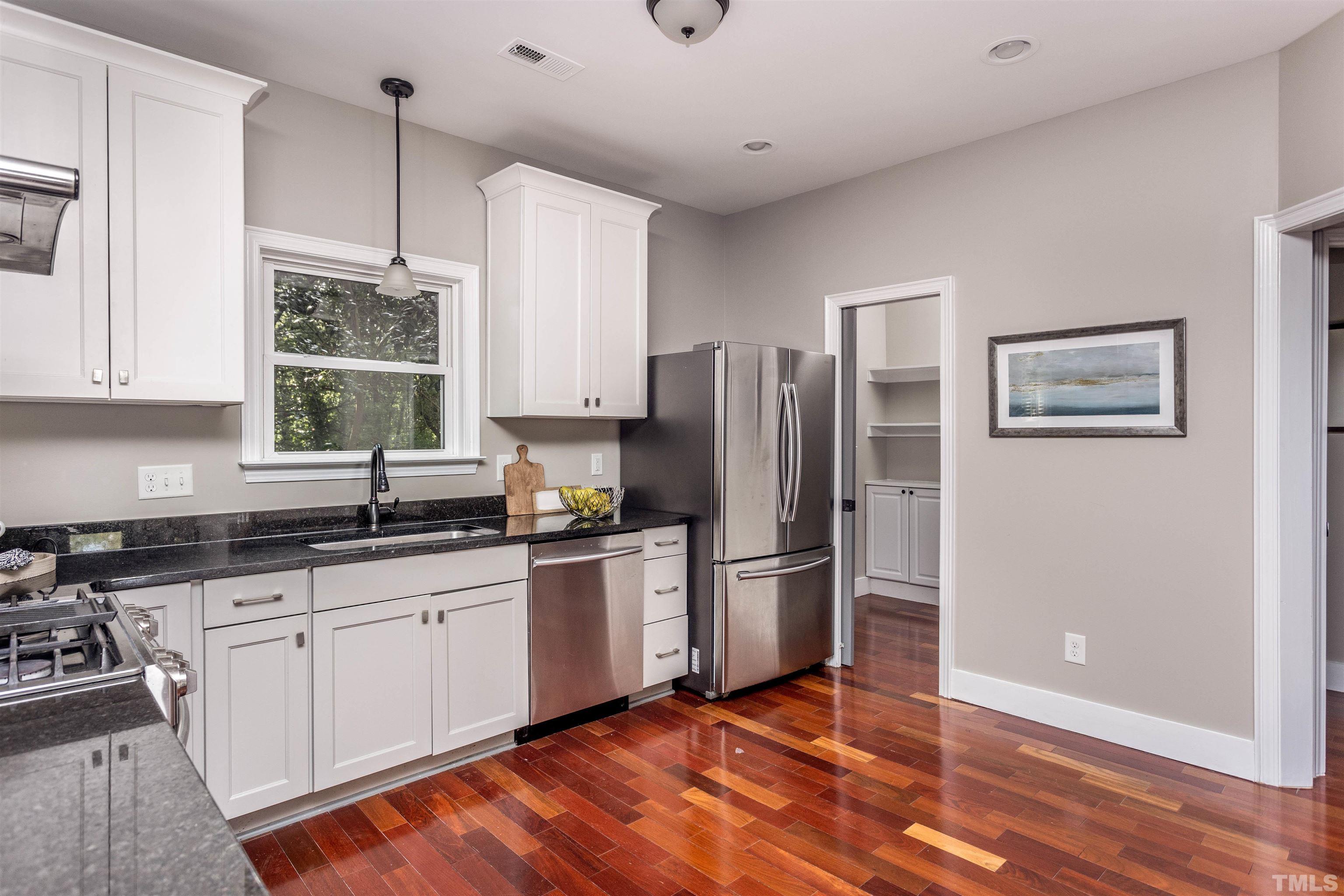 312 Freeman Street Raleigh, NC 27601 - Photo 9 of 30 a kitchen with granite countertop a refrigerator cabinets and wooden floor
