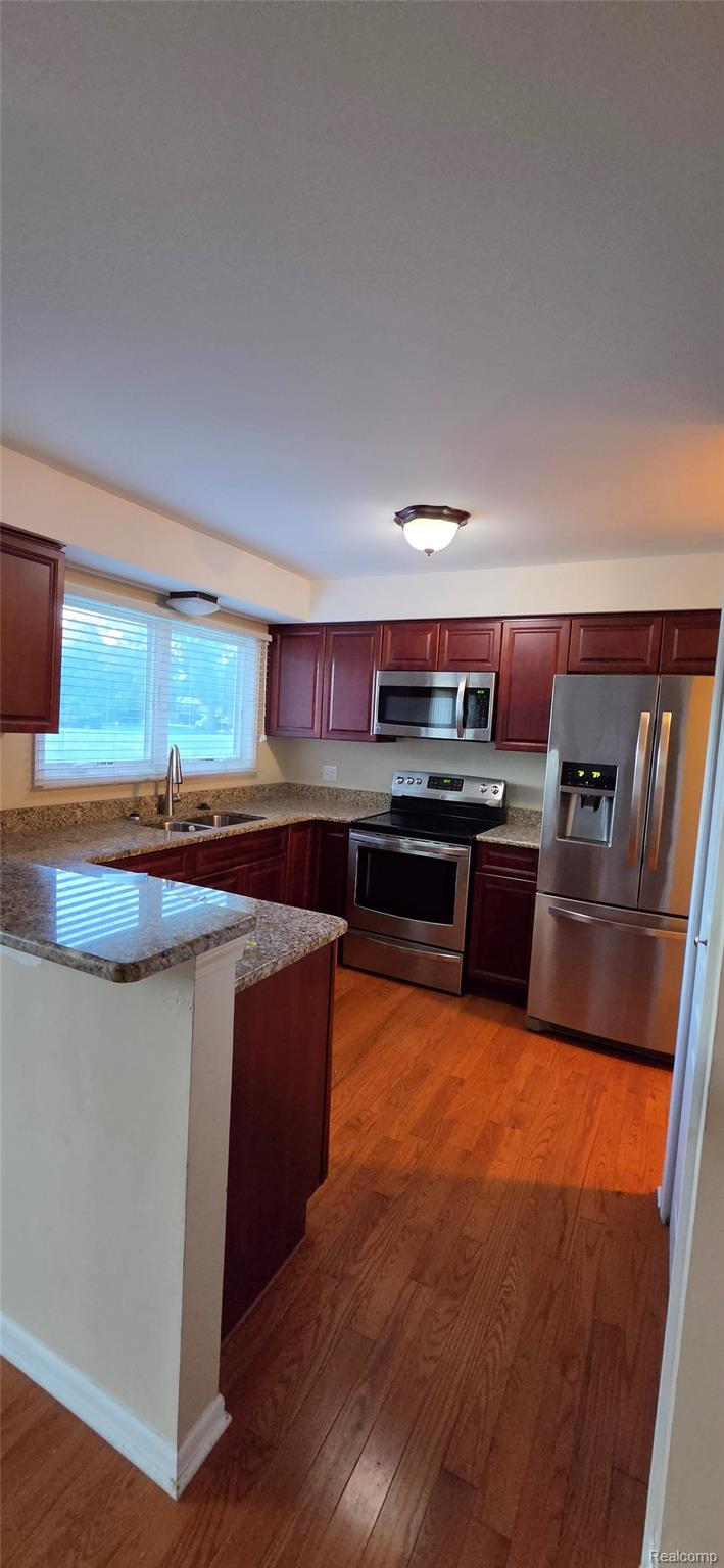 380 Huntington Court Rochester, MI 48307 - Photo 8 of 26 Kitchen featuring wood-finish flooring, granite countertops, and stainless steel appliances