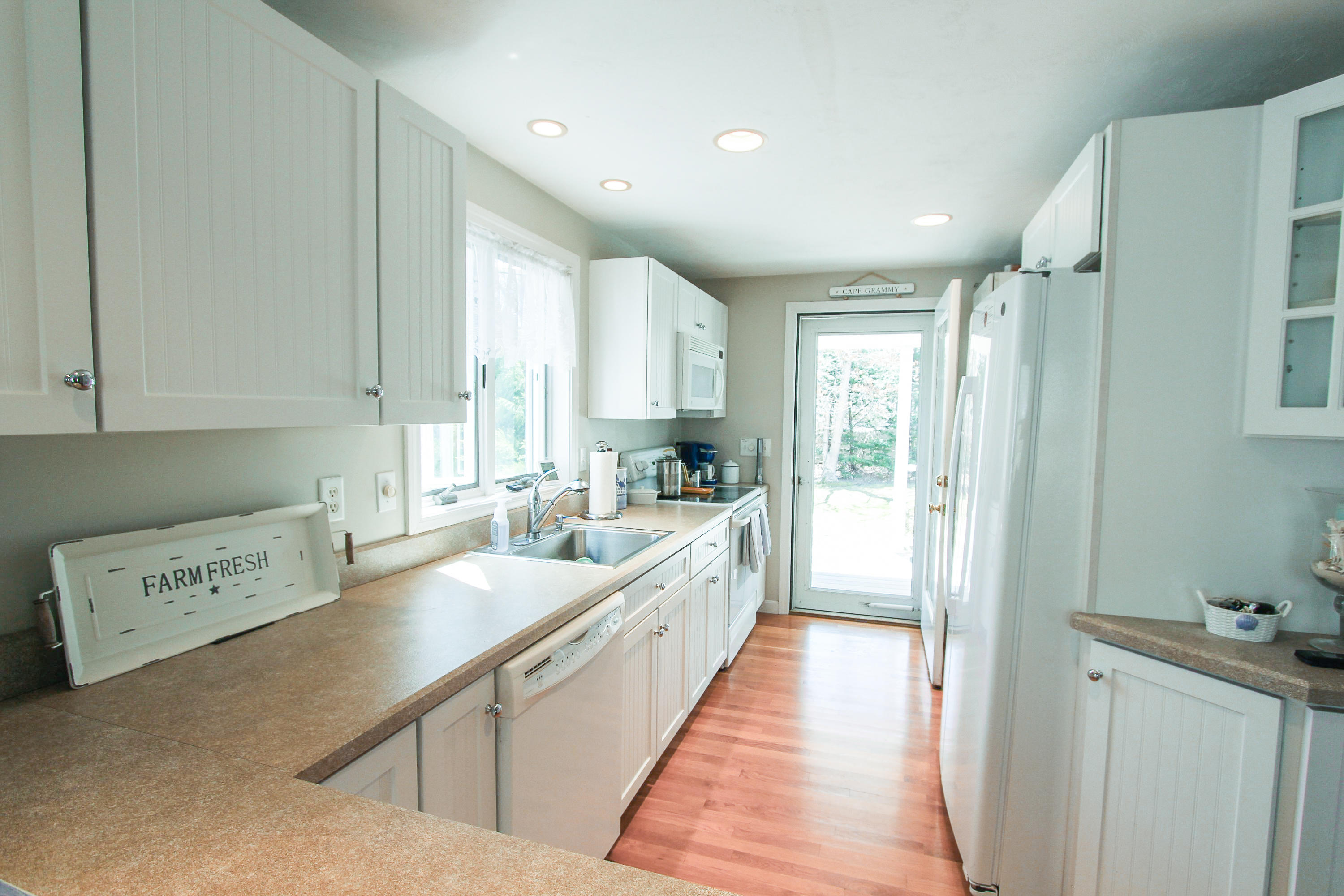 49 Suomi Road Hyannis, MA 02601 - Photo 49 of 59 a large white kitchen with stainless steel appliances granite countertop a refrigerator a sink a stove and white cabinets