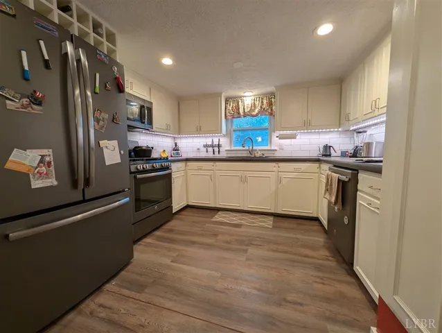 a kitchen with stainless steel appliances granite countertop a sink and a stove