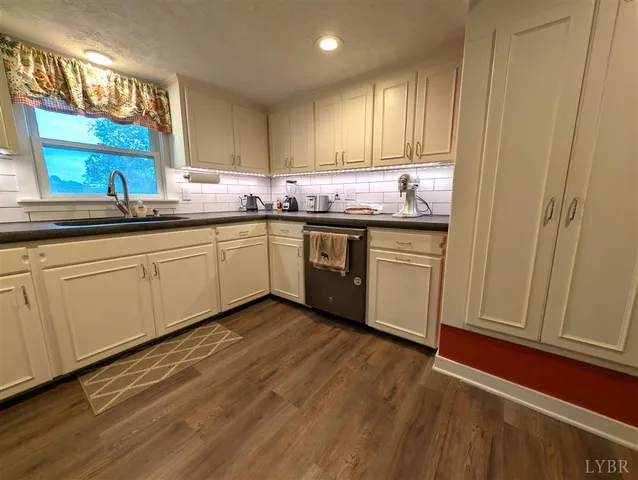a kitchen with granite countertop cabinets stainless steel appliances and a sink
