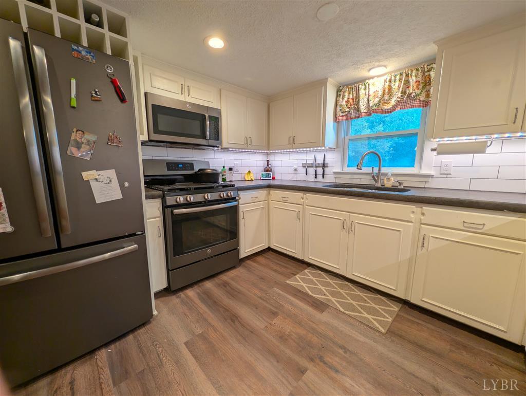 4470 Red Oak School Road Concord, VA 24538 - Photo 13 of 30 a kitchen with stainless steel appliances granite countertop a stove a sink and a microwave