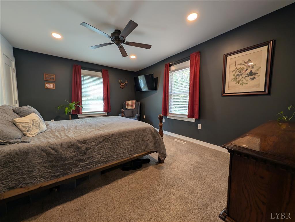 4470 Red Oak School Road Concord, VA 24538 - Photo 15 of 30 a bedroom with a large bed chandelier and a window