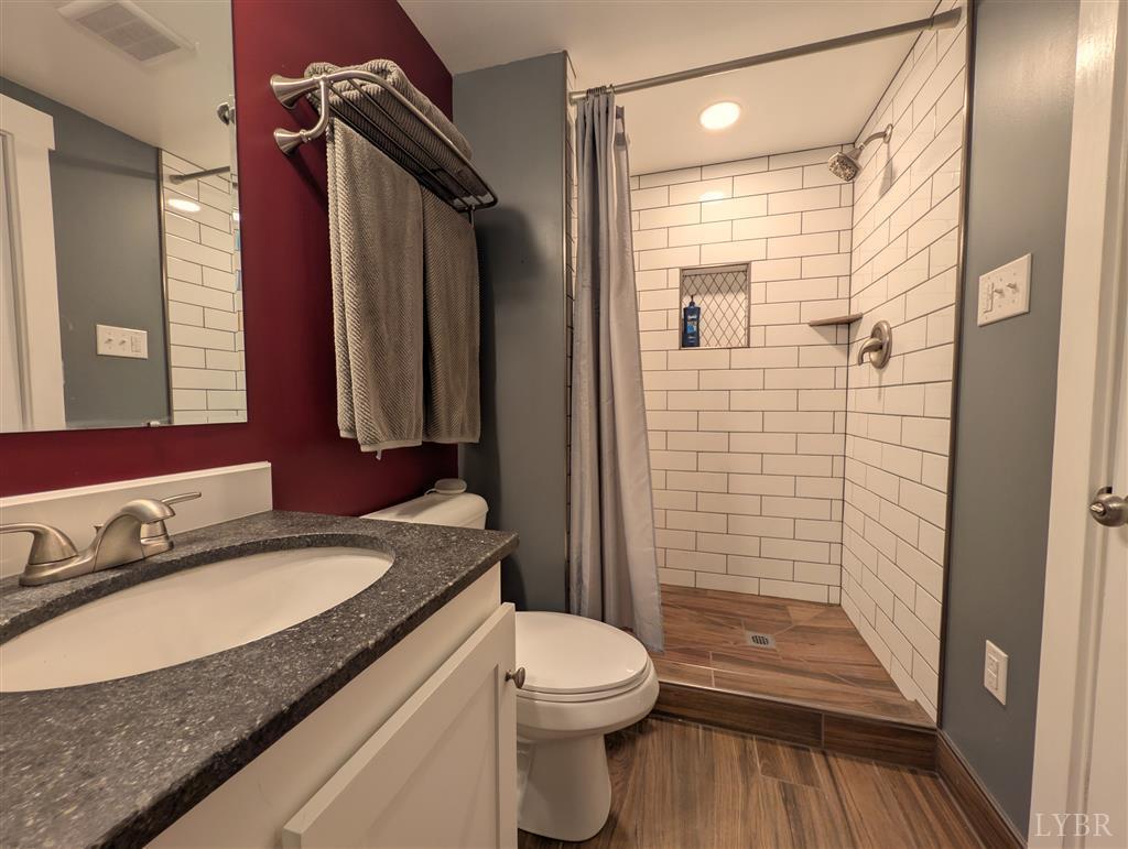4470 Red Oak School Road Concord, VA 24538 - Photo 17 of 30 a bathroom with a granite countertop sink toilet and shower