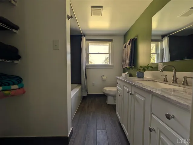 a bathroom with a double vanity sink and mirror with toilet