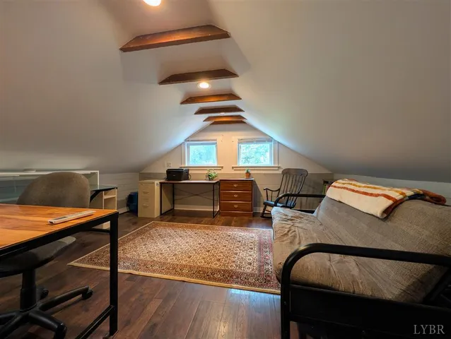 a living room with furniture and a dining table with wooden floor