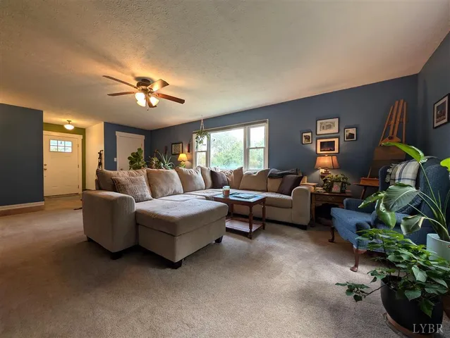 a living room with furniture a chandelier and a window
