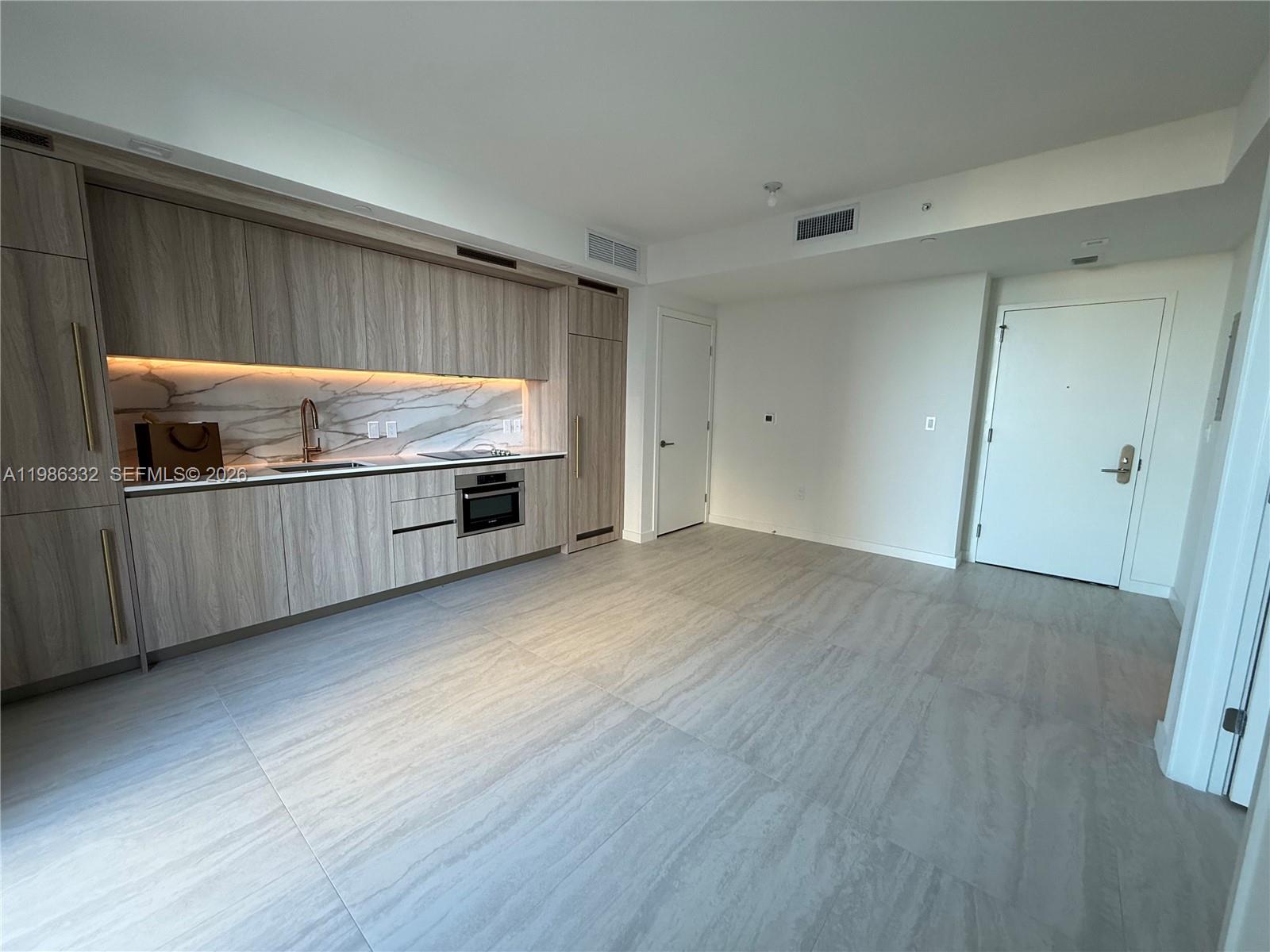 77 Southeast 5th Street, Unit 2015 Miami, FL 33131 - Photo 2 of 70 a kitchen with stainless steel appliances wooden cabinets and a sink