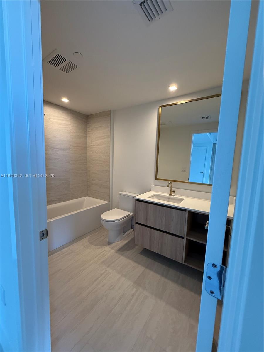 77 Southeast 5th Street, Unit 2015 Miami, FL 33131 - Photo 23 of 70 a bathroom with a double vanity sink a mirror and a bathtub