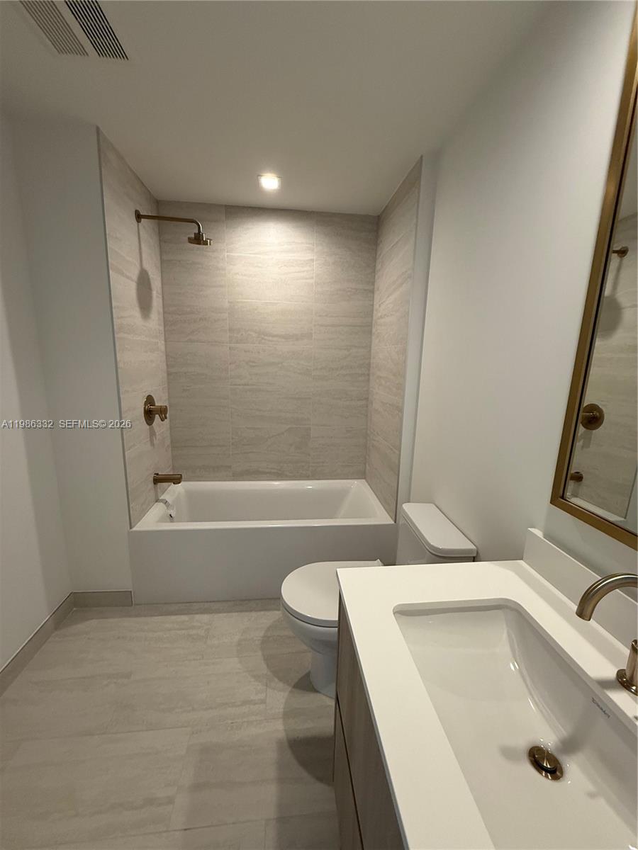 77 Southeast 5th Street, Unit 2015 Miami, FL 33131 - Photo 8 of 70 a bathroom with a sink a toilet and tub