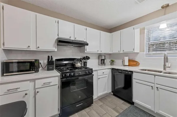 a kitchen with white cabinets and appliances