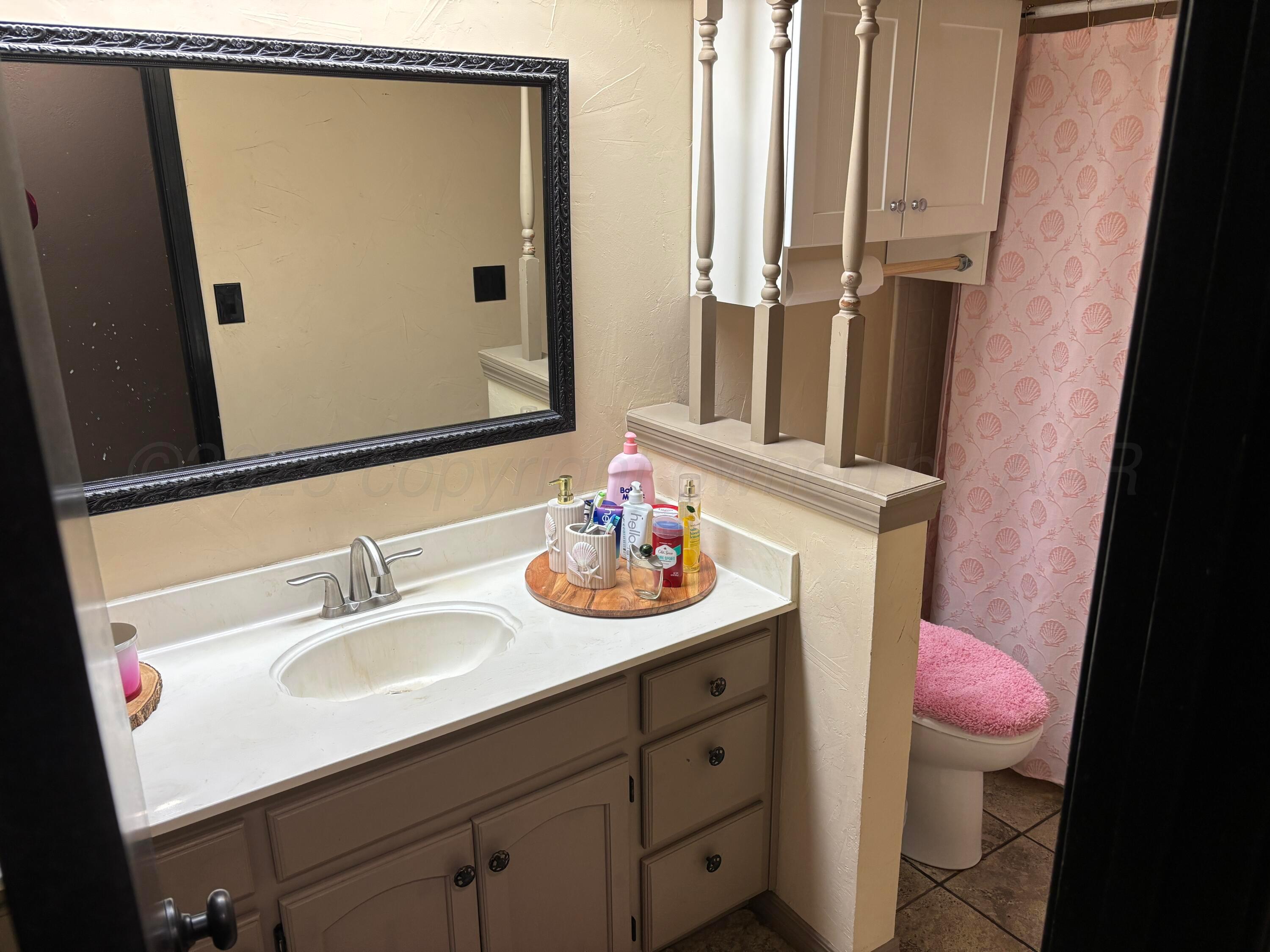 7810 Farrell Drive Amarillo, TX 79121 - Photo 14 of 31 a bathroom with a sink mirror vanity and toilet