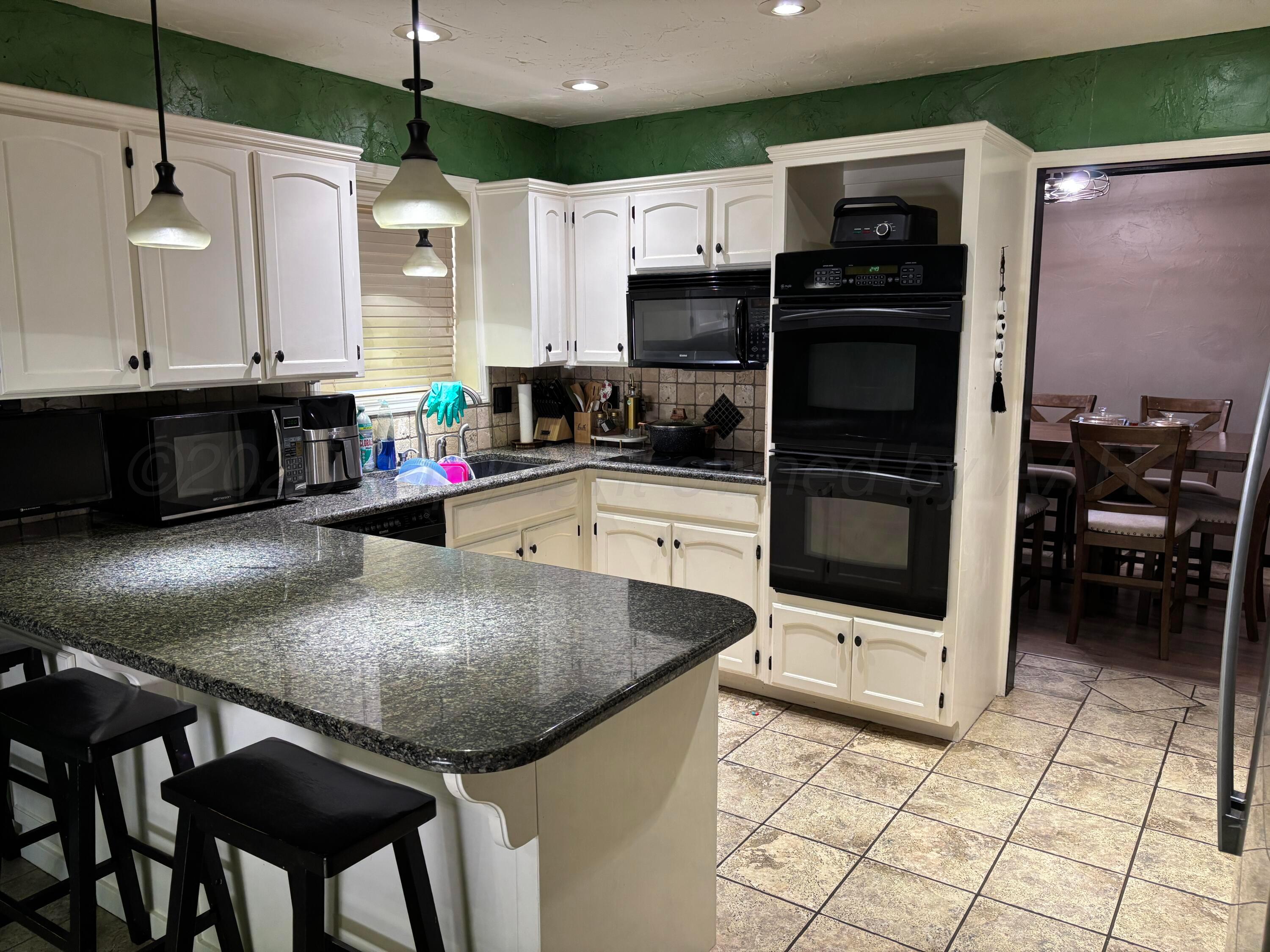 7810 Farrell Drive Amarillo, TX 79121 - Photo 19 of 31 a kitchen with stainless steel appliances granite countertop a sink a stove and cabinets