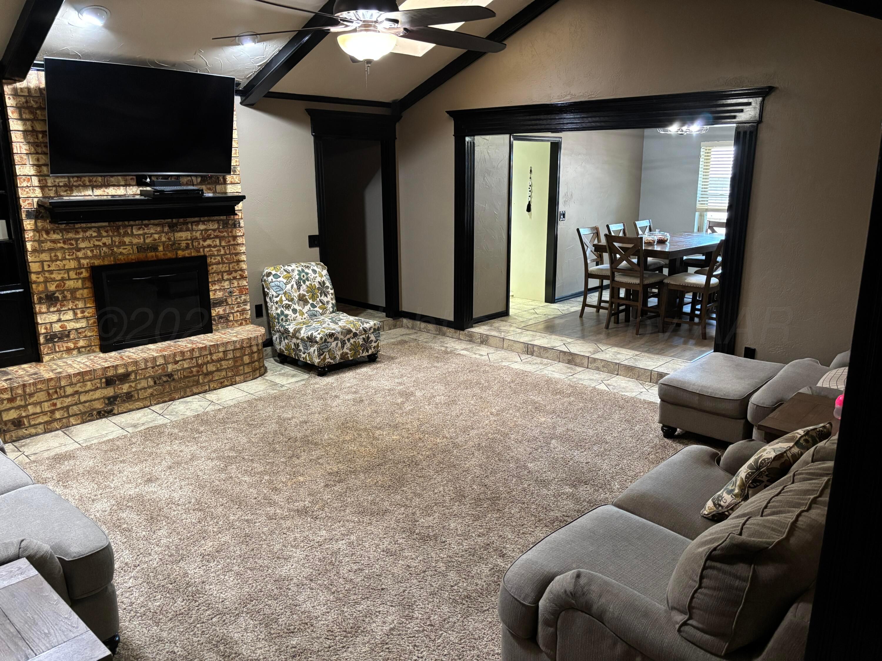 7810 Farrell Drive Amarillo, TX 79121 - Photo 22 of 31 a living room with furniture a flat screen tv and a fireplace