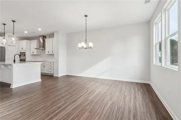a view of a kitchen with stove and wooden floor