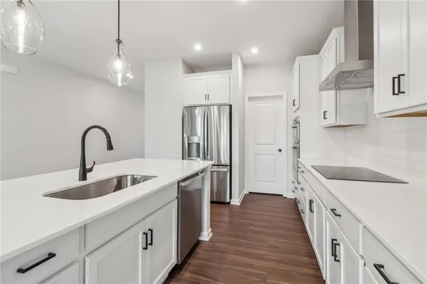 a kitchen with kitchen island stainless steel appliances a sink stove and refrigerator
