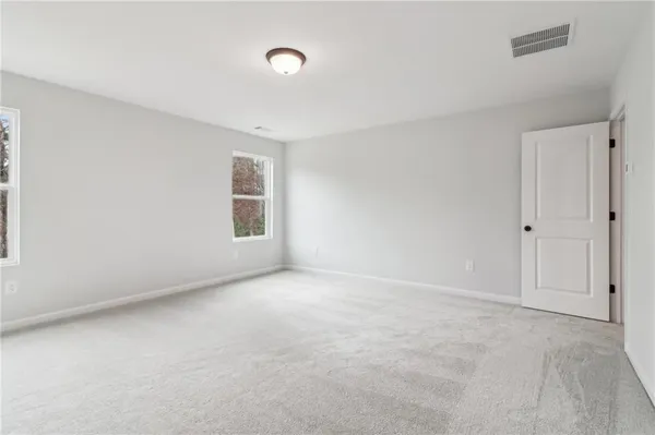 a spacious bathroom with double vanity a mirror and a shower