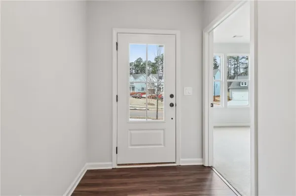 an empty room with wooden floor closet and windows