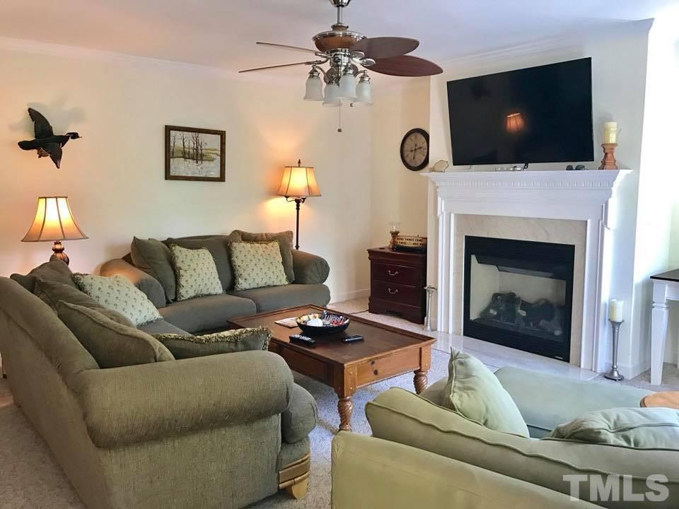 205 Hidden Hills Road Roxboro, NC 27574 - Photo 8 of 18 a living room with furniture a flat screen tv and a fireplace
