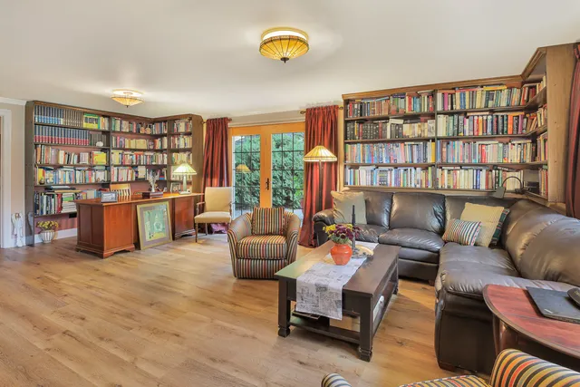 a living room with furniture and a book shelf