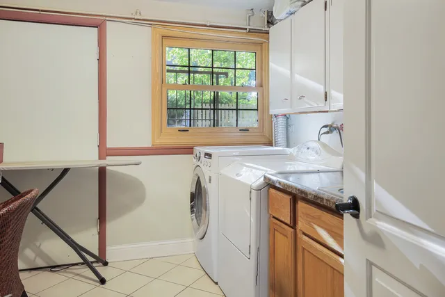 a utility room with granite countertop cabinets washer and dryer