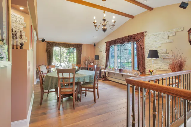 a dining room with furniture a chandelier and wooden floor